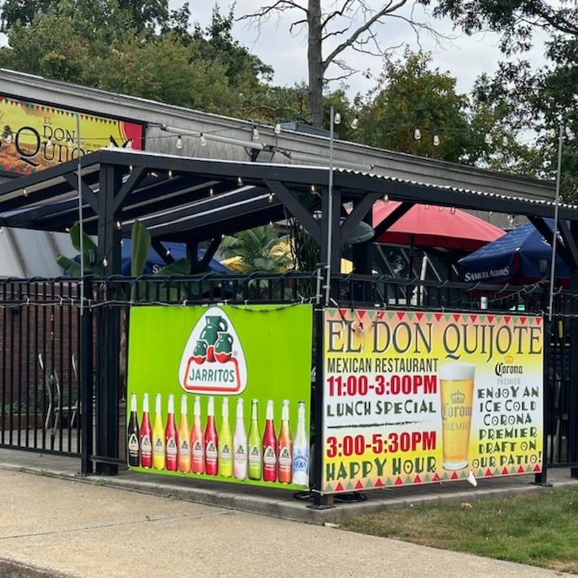 Exterior of El Don Quijote Mexican Restaurant with patio seating, umbrellas, and promotional banners.